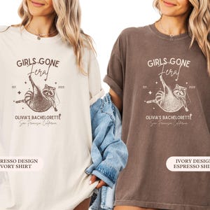 May include: Two t-shirts, one cream and one brown, display a raccoon graphic with the words "GIRLS GONE FERAL" and "OLIVIA'S BACHELORETTE San Francisco California". The design includes the year 2025 and stars.