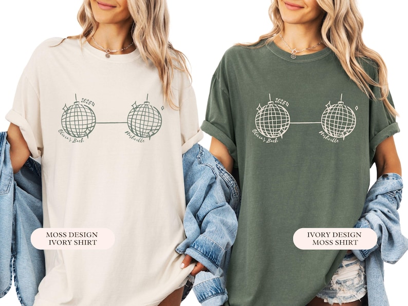 May include: Two oversized t-shirts, one cream and one dark green, each with a graphic of two disco balls linked by a line. The text "2025" is above the disco balls, with "Olivia's Bach" and "Nashville" below. The cream shirt is labelled "Moss Design Ivory Shirt".