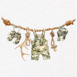 May include: A decorative rope garland featuring camouflage-patterned baby overalls, a pair of matching booties, a baseball cap, a pacifier, and a deer antler. The items are suspended from a thick, twisted brown rope with knotted ends.