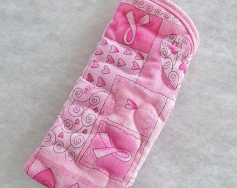 Könnte beinhalten: Rosa gesteppter Topflappen mit einem rosa Band und einem Herz-Design. Der Topflappen ist aus Stoff und hat eine gesteppte Textur.