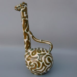 May include: A ceramic giraffe-shaped vase with a white background and brown and green abstract patterns.