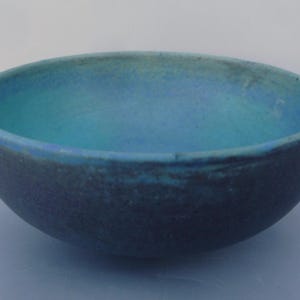 May include: A blue and green ceramic bowl with a textured surface. The bowl is round and has a wide rim.