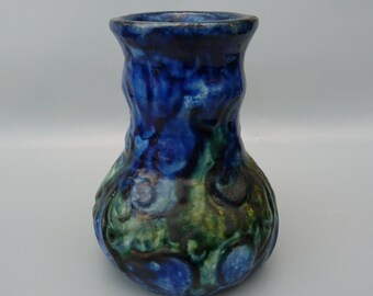 May include: A blue and green ceramic vase with a textured surface. The vase has a wide mouth and a rounded body.