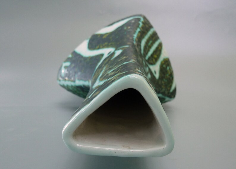 Puede incluir: Un jarr&oacute;n de cer&aacute;mica con una abertura triangular y un patr&oacute;n abstracto verde y blanco.