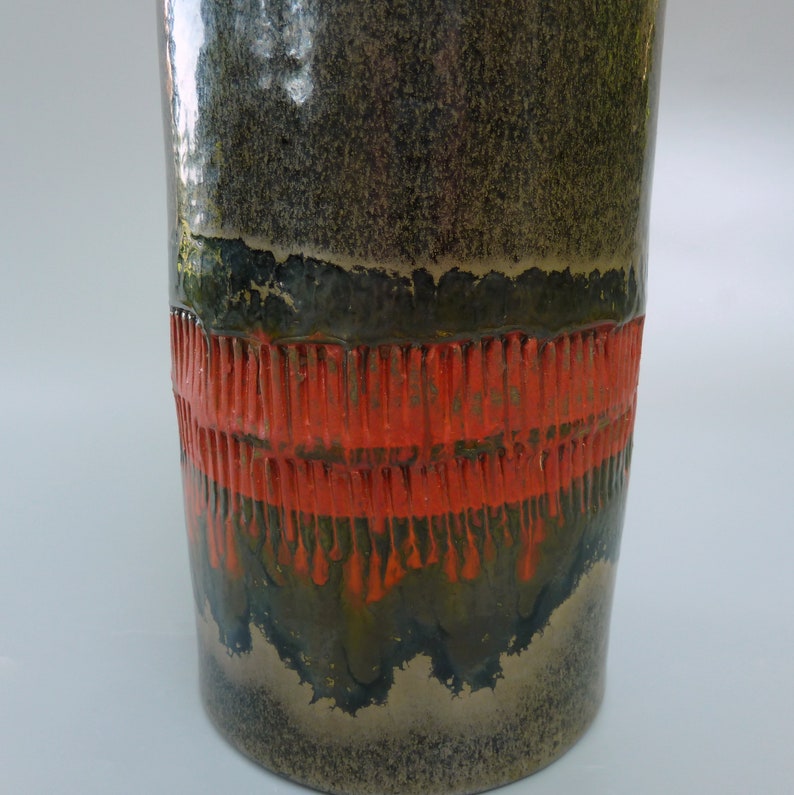 May include: A ceramic vase with a dark green and brown glaze. The vase has a band of orange glaze around the middle.