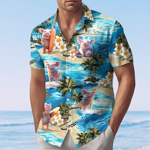 May include: Short-sleeved button-down shirt with a tropical beach scene featuring cartoon pigs. The shirt has a blue background with palm trees, waves, and white flowers. The pigs are wearing sunglasses and enjoying the beach.