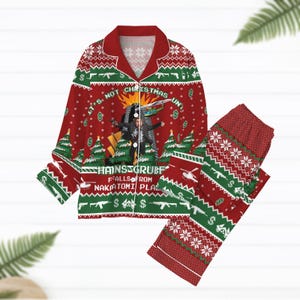 May include: Red and green Christmas-themed pajama set. The top features a festive design with the text "It's Not Christmas Until" and a graphic. The pants have a matching pattern. The set includes a collared shirt and pants.