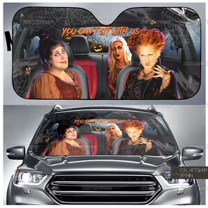 May include: A black car windshield sunshade with a spiderweb design and the text "You Can't Sit With Us". Three women from the movie Hocus Pocus are featured on the sunshade. The women are dressed in costumes from the movie.