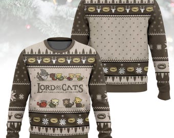 May include: A brown and beige Christmas sweater with a repeating pattern of trees, deer, and rings. The front features the text "Lord of the Cats" with cartoon cat characters. The back of the sweater has a similar design.