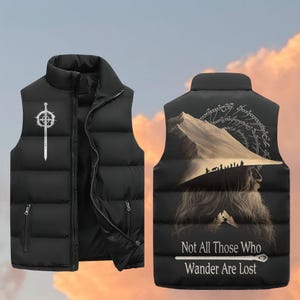 May include: Black puffer vest with a white sword and shield design on the front. The back features a mountain scene with figures and the text "Not All Those Who Wander Are Lost."