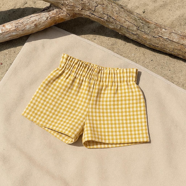 May include: Yellow and white gingham shorts with a gathered elastic waistband.