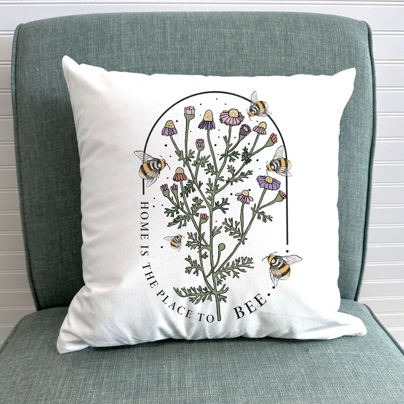 a pillow with a picture of a plant with bees on it