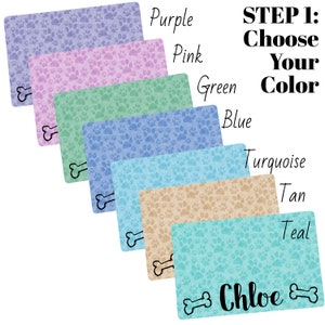 May include: A set of six dog food mats in various colors, including purple, pink, green, blue, turquoise, and teal. Each mat features a paw print pattern and a bone design. The mat in the bottom row has the name "Chloe" written on it.