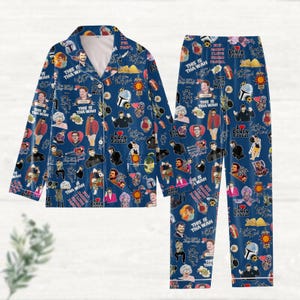 Peut inclure: Ensemble de pyjama bleu avec un motif répété d'images et de texte. L'ensemble comprend une chemise boutonnée et un pantalon. Le motif présente des images de personnes, de cœurs et de texte, dont "This is Tha Wah" et "Pedro Pascal".