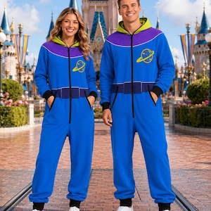May include: A blue one-piece jumpsuit featuring a front zipper closure, a lime green hood lining, and a purple yoke. The garment includes a yellow planet graphic on the chest, black sleeve cuffs, and a printed dark blue belt detail at the waist.