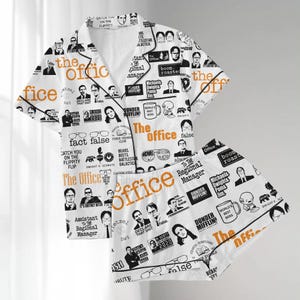 Può includere: Pigiama bianco con un motivo ripetuto di personaggi e citazioni di "The Office". Il set include una camicia con bottoni e pantaloncini abbinati, con finiture nere e testo arancione.