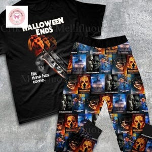 Peut inclure: Ensemble de pyjama noir sur le thème d'Halloween. Le t-shirt à manches courtes porte l'inscription "HALLOWEEN ENDS" et un graphisme d'un personnage avec un couteau. Le pantalon de pyjama est recouvert d'images de la franchise Halloween. Le texte "His time has come." est également sur le t-shirt.