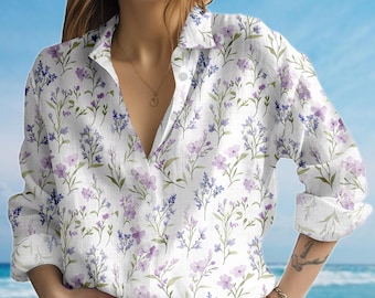 May include: White button-down shirt with a floral pattern of purple and lavender flowers and green stems. The long-sleeved shirt has a classic collar and is unbuttoned at the neckline.
