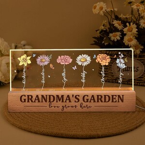 May include: A wooden LED light with the text "GRANDMA'S GARDEN" and "love grows here". The light features colorful flower illustrations with names: Richara, Sandra, Cynthia, Bobby, Christine, and Terry.