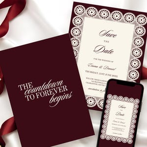 May include: Burgundy wedding stationery set with a "Save the Date" card, a matching invitation, and a smartphone displaying the invitation. The invitation features a decorative lace border and the text "Save the Date". The card reads "The countdown to forever begins".