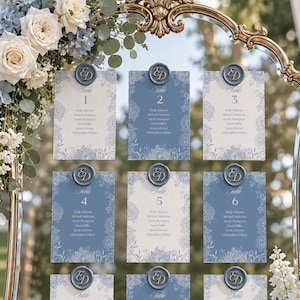 Cartoncini per la disposizione dei posti a sedere per matrimoni color blu polvere, modello di numero di tavolo modificabile in Canva, cartello per la disposizione dei posti a sedere del ricevimento con ortensie (scaricabile).