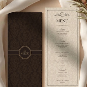 Może przedstawiać: Pionowa karta menu weselnego z ciemnobrązowym panelem w damasceński wzór i okrągłym logo oraz kremowym panelem z czarnym tekstem wymieniającym dania, takie jak sałatka z rukoli, pieczony kurczak i tort weselny dla Emmy i Daniela.
