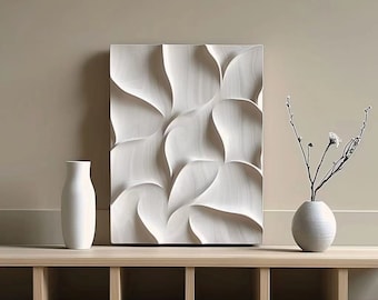 May include: A white wooden wall sculpture with a flowing, organic design. The sculpture is displayed on a light wood shelf with two white ceramic vases, one with a small bouquet of dried flowers.