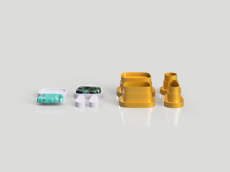 Op de afbeelding: Een set van vijf gele plastic koekjesvormen in verschillende vormen, waaronder een rechthoek, een cirkel en een hart. De vormen zijn gerangschikt op een wit oppervlak.