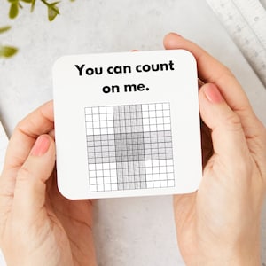 Peut inclure: Sous-verre blanc avec le texte "You can count on me." et un motif de grille noir et blanc.