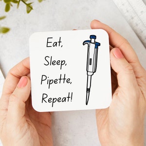 Peut inclure: Sous-verre carré blanc avec du texte noir qui dit "Manger, Dormir, Pipeter, Répéter !" et une illustration en noir et blanc d'une pipette.