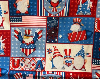 May include: A patriotic fabric featuring a repeating pattern of red, white, and blue squares. Each square showcases American flag imagery, gnomes in patriotic hats, and the Statue of Liberty. The word "USA" is also visible in the design.
