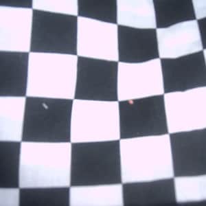 May include: Black and white checkered fabric. The fabric has a smooth, even texture.