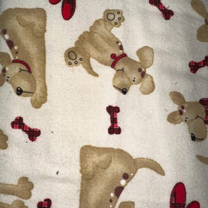 May include: Cream-colored fabric featuring a repeating pattern of cartoon dogs in various poses, red dog bones, and red slippers. The dogs are tan with brown spots and wear red collars. The overall design is playful and suitable for pet-themed items.