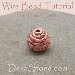 May include: A close-up of a copper wire bead tutorial. The bead is made of copper wire and is coiled into a round shape. The bead is sitting on a gray stone surface. The text "Wire Bead Tutorial by: Delia Stone" is visible at the top of the image.