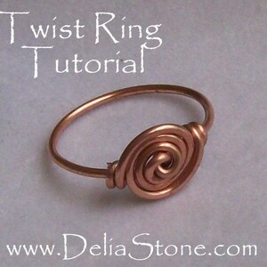 Op de afbeelding: Een koperen draadring met een gedraaid spiraalontwerp. De ring ligt op een lichtgrijze achtergrond. De tekst "Twist Ring Tutorial" staat bovenaan de afbeelding en "www.DeliaStone.com" onderaan.