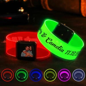 May include: Glowing LED wristbands in red and green, with a black square featuring a couple's photo. The green band is inscribed with "my & Camelia 11.12.20". Additional wristbands in various colors are displayed below.