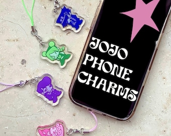 Op de afbeelding: Vier acryl telefoonhangers met gestileerde karakterillustraties in blauw, groen, paars en roze, elk met een bijpassend koordje. Een smartphone toont een roze ster en de tekst JOJO PHONE CHARMS in witte letters.