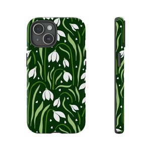Könnte beinhalten: Eine grüne Handyhülle mit einem weißen Blumenmuster. Die Hülle hat einen Ausschnitt für die Kamera.