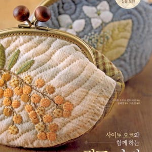 May include: A close-up of a beige quilted coin purse with a floral design. The purse has a brass frame and a wooden clasp. The text "100% 실물 도안" is visible in the upper right corner of the image.