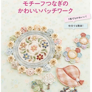 May include: A book cover with a pink background and a floral design. The title of the book is "Motifs for Patchwork" and the subtitle is "Cute Patchwork". The book cover also includes the text "1 piece is cute!" and "Easy to make!"
