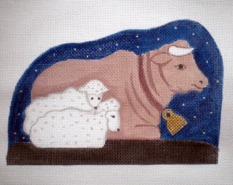 May include: A brown cow with a gold bell around its neck is lying down with three white lambs. The scene is set against a blue background with white stars.