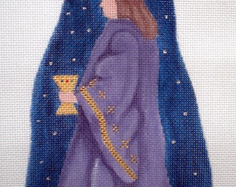May include: A purple-robed figure with a gold crown and a gold chalice in their hand, standing in front of a blue background with white stars.