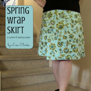 Puede incluir: Un tutorial para una falda envolvente a medida con estampado floral. La falda es azul claro con flores verdes y blancas. El texto "Spring Wrap Skirt" está en un cuadro blanco con fondo azul claro. El texto "a custom-fit sewing project" está debajo del título. El texto "by Lisa Clarke" está debajo de la descripción del proyecto. El texto "a fully-illustrated, step-by-step tutorial presented by Polka Dot Cottage" está en la parte inferior de la imagen.