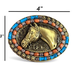 May include: Oval belt buckle, 10 cm wide and 7.6 cm tall, with a brass horse head design. The buckle is decorated with turquoise and orange stones around the edge, creating a decorative western style.