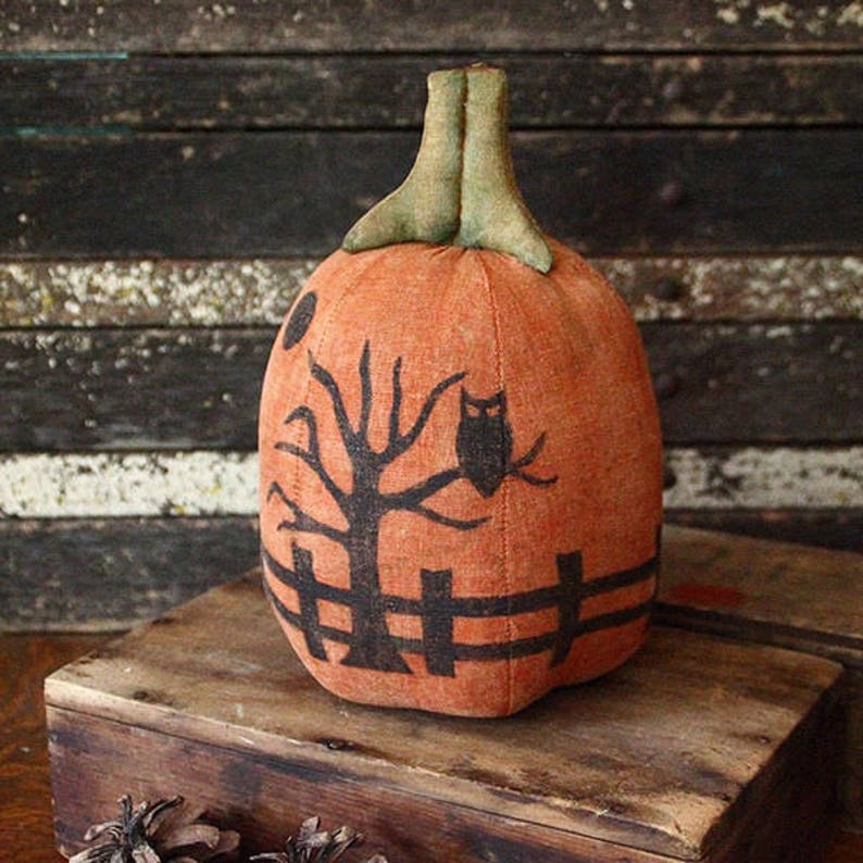 May include: A handmade orange fabric pumpkin with a black silhouette of a tree, fence, and owl. The pumpkin is decorated with a black and white design.
