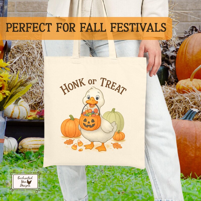 May include: Cream-colored tote bag featuring a cartoon duck holding a jack-o'-lantern bucket filled with candy. The words "Honk or Treat" are above the duck. Pumpkins and fall leaves are in the background. The bag is perfect for fall festivals.