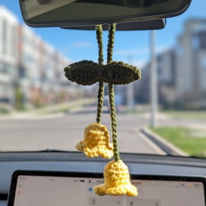 Yellow lily of the valley charm hanging on rear-view mirror