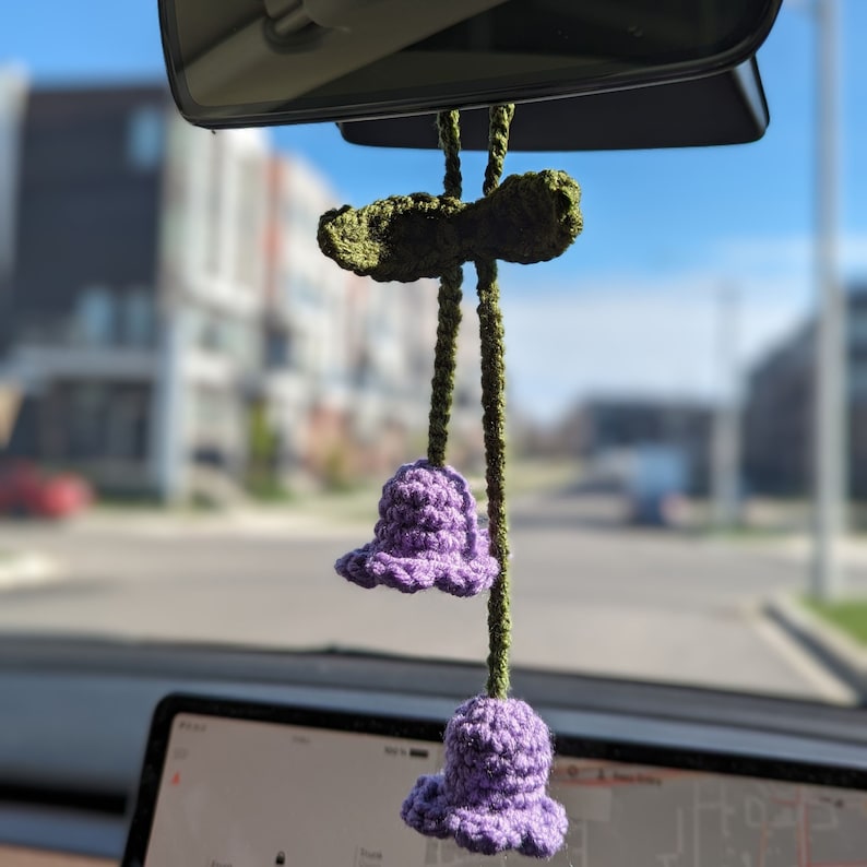 Purple lily of the valley charm hanging on rear-view mirror