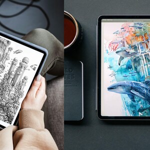 May include: Two tablets displaying artwork. One shows a black and white architectural drawing with fish. The other tablet displays a watercolor painting of whales and an underwater scene. A stylus and a notebook are also visible.