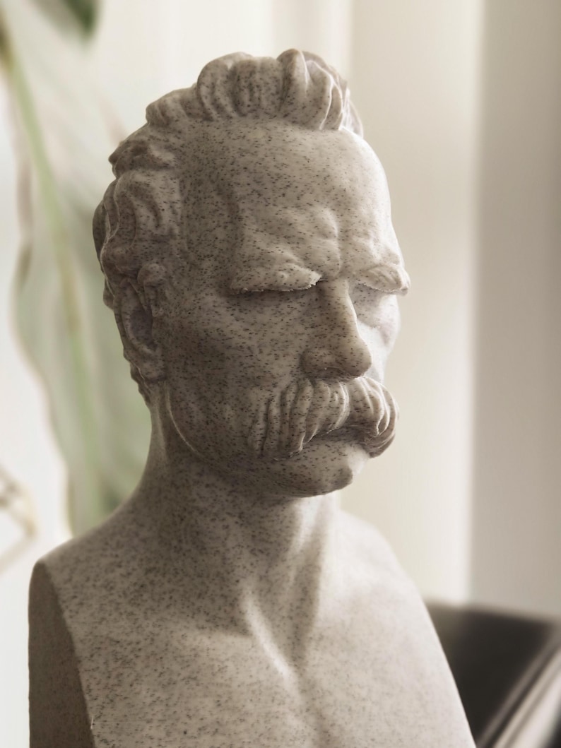 May include: A white marble bust sculpture of a man with a mustache and closed eyes.